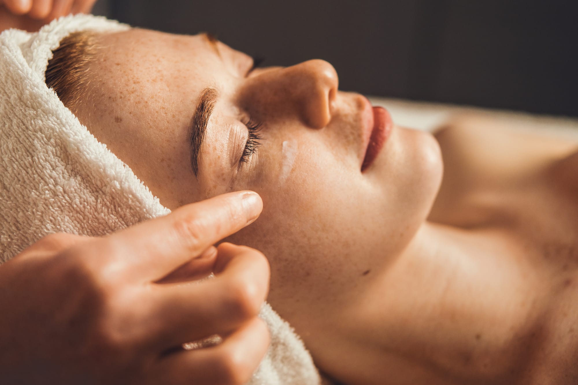 A practitioner giving a facial treatment