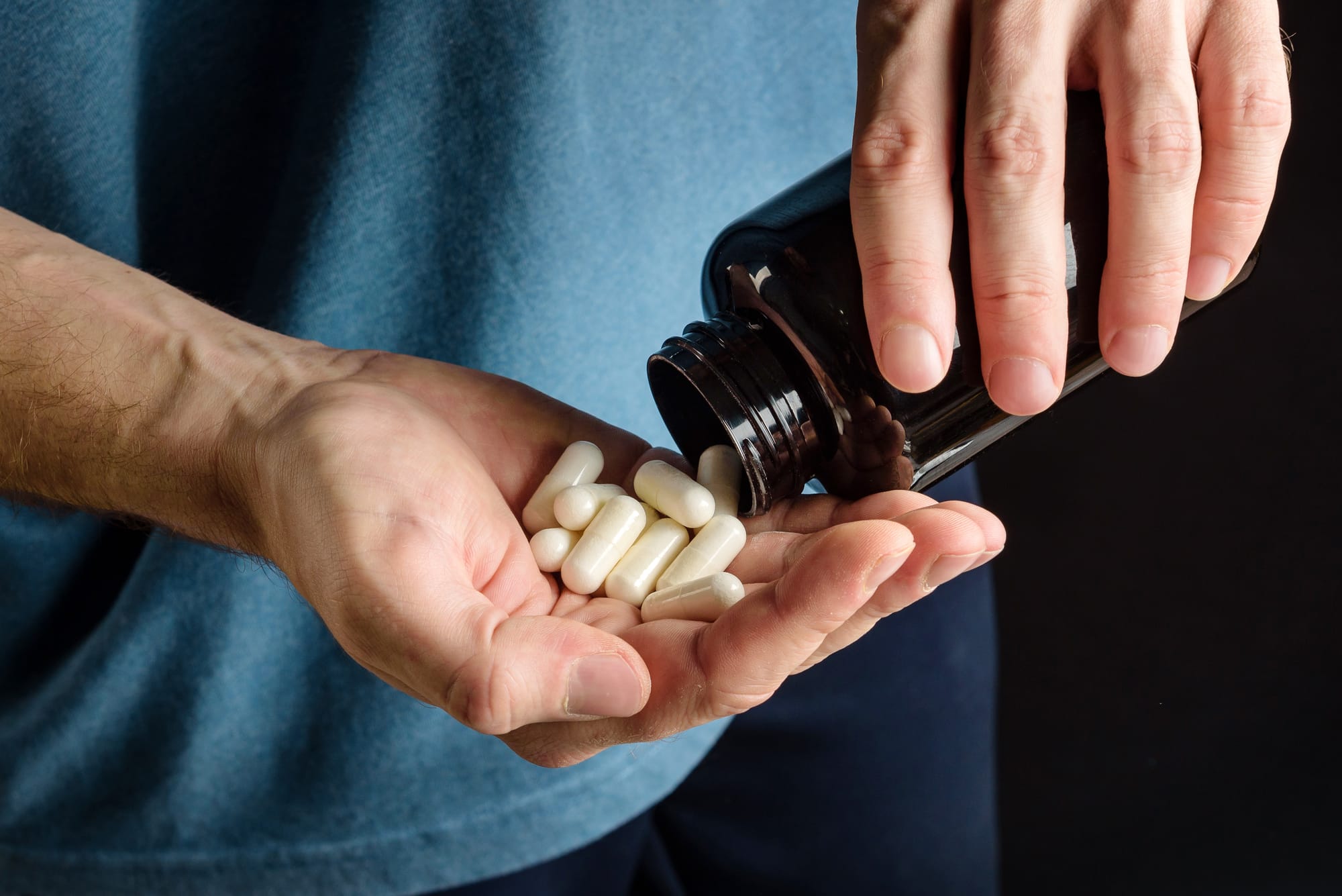 Supplement capsules poured into a hand